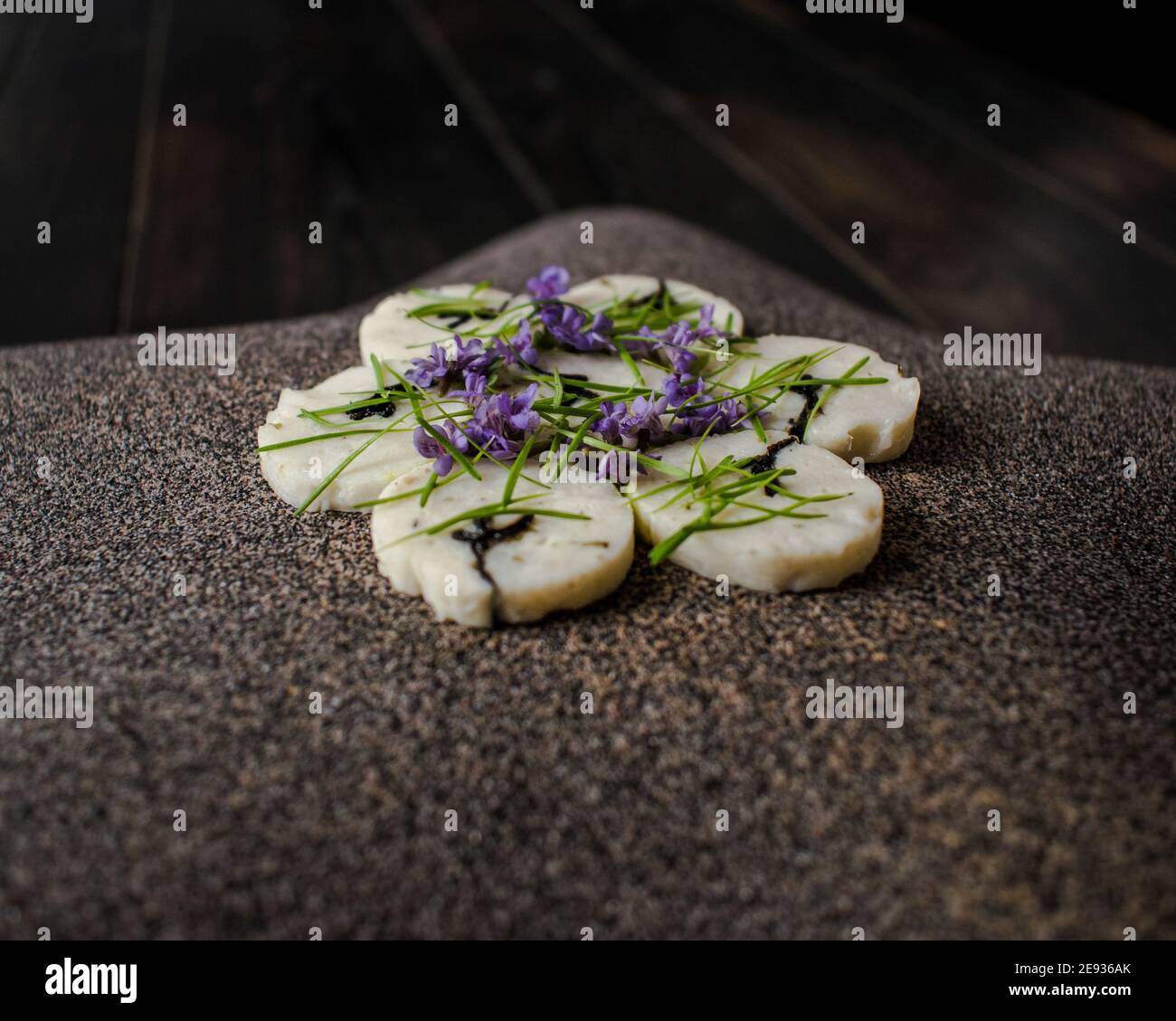 Fischroulade auf einem interessanten Teller, der mit Tannennadeln verziert ist In einem Restaurant Stockfoto