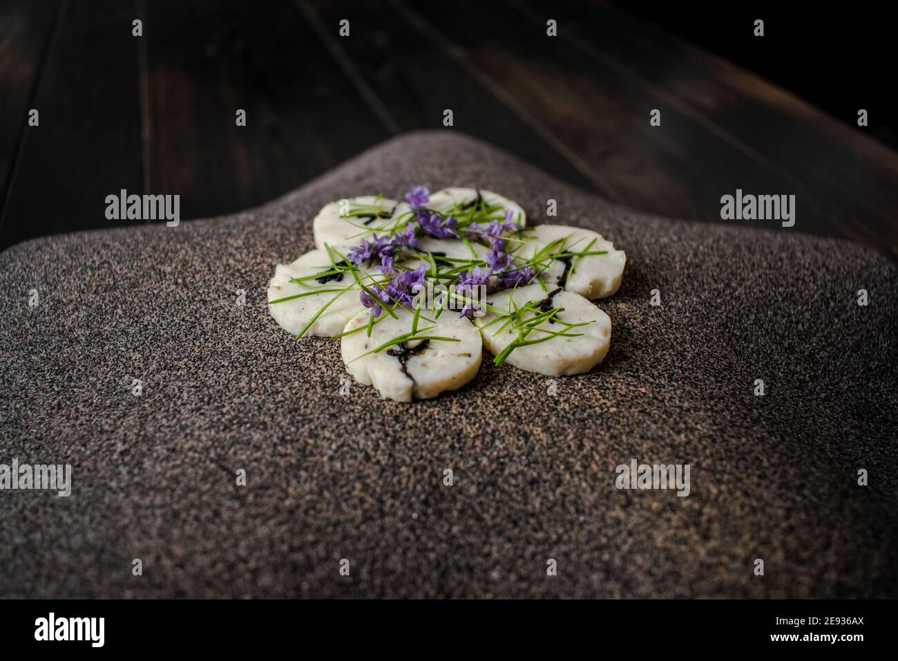 Fischroulade auf einem interessanten Teller, der mit Tannennadeln verziert ist In einem Restaurant Stockfoto