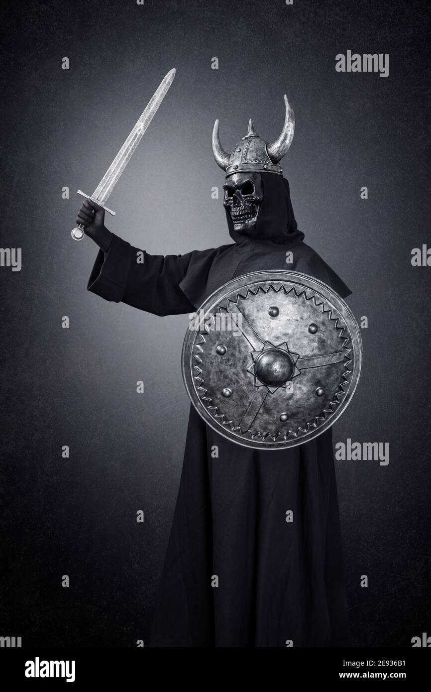 Skelett Krieger mit gehörnten Helm, Schwert und runden Schild in der  Dunkelheit Stockfotografie - Alamy