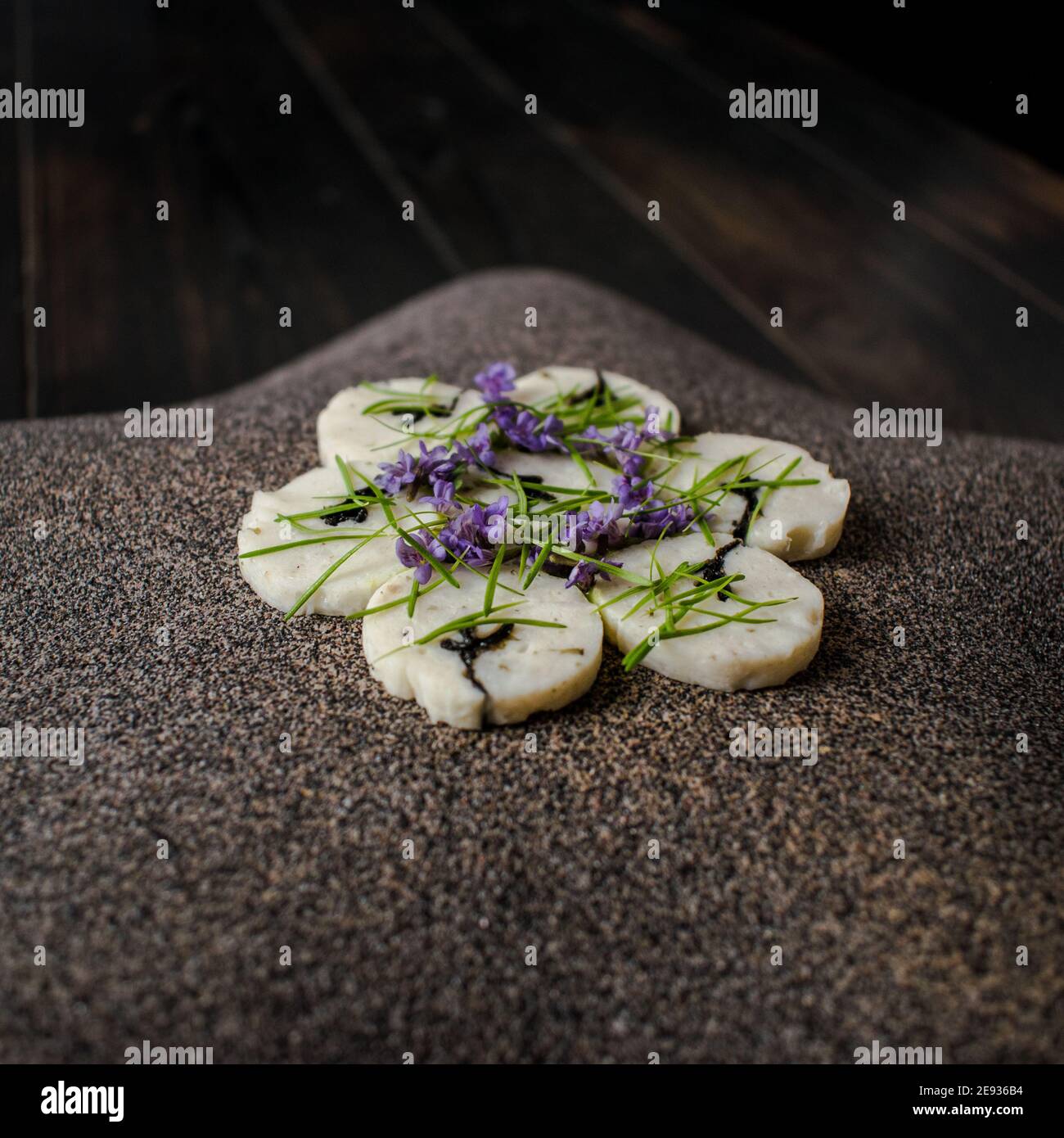 Fischroulade auf einem interessanten Teller, der mit Tannennadeln verziert ist In einem Restaurant Stockfoto