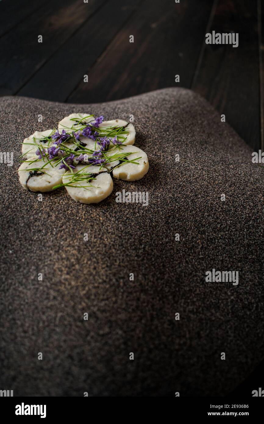 Fischroulade auf einem interessanten Teller, der mit Tannennadeln verziert ist In einem Restaurant Stockfoto