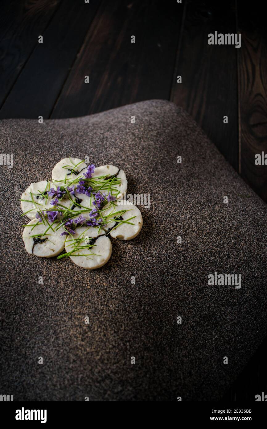 Fischroulade auf einem interessanten Teller, der mit Tannennadeln verziert ist In einem Restaurant Stockfoto