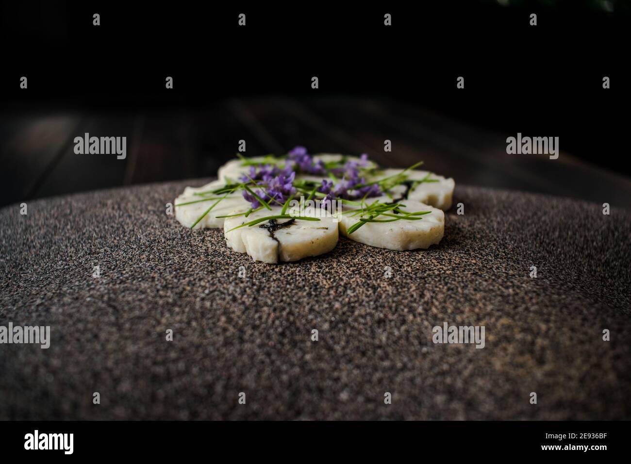 Fischroulade auf einem interessanten Teller, der mit Tannennadeln verziert ist In einem Restaurant Stockfoto