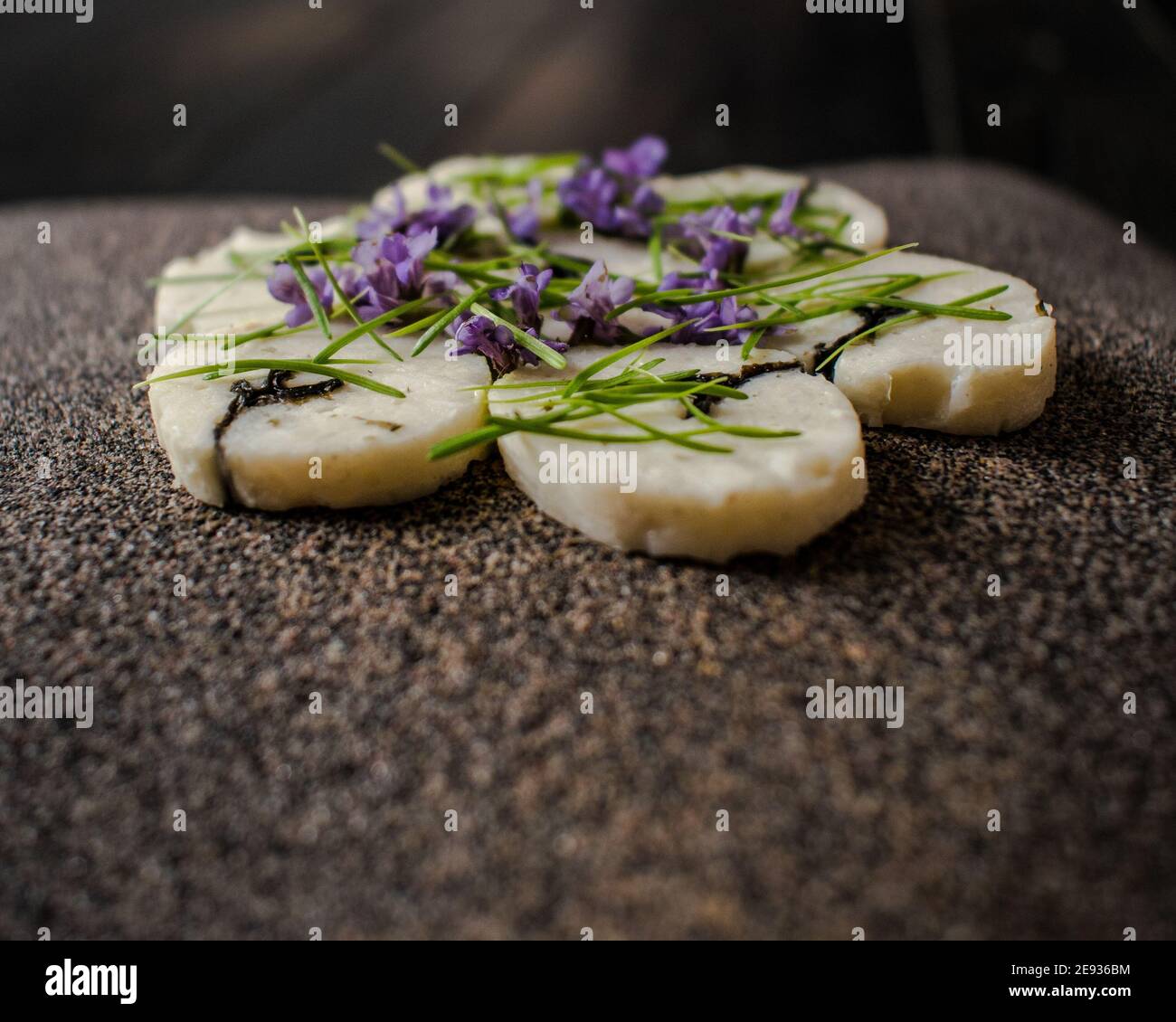Fischroulade auf einem interessanten Teller, der mit Tannennadeln verziert ist In einem Restaurant Stockfoto