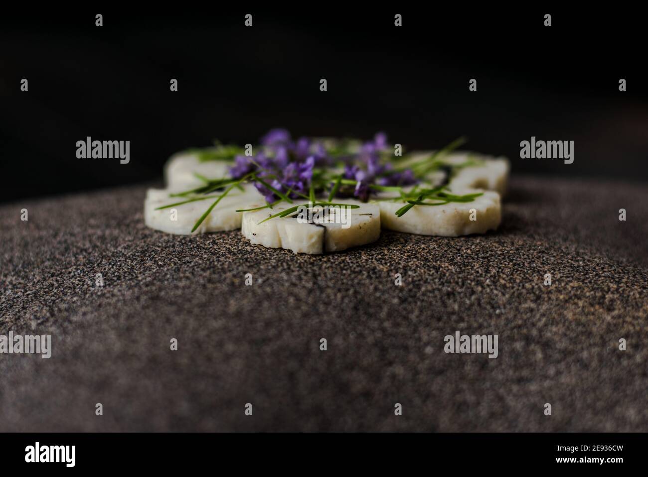 Fischroulade auf einem interessanten Teller, der mit Tannennadeln verziert ist In einem Restaurant Stockfoto