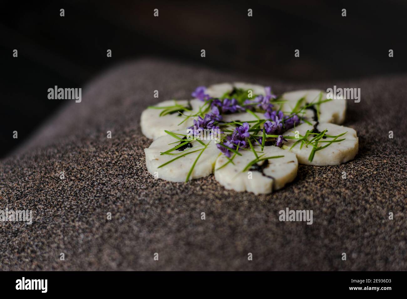 Fischroulade auf einem interessanten Teller, der mit Tannennadeln verziert ist In einem Restaurant Stockfoto