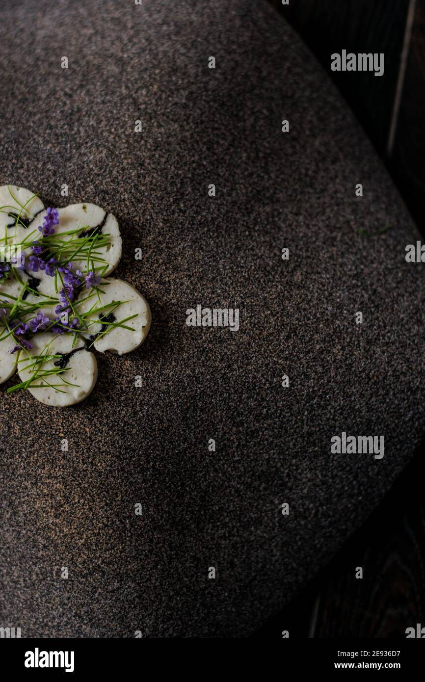 Fischroulade auf einem interessanten Teller, der mit Tannennadeln verziert ist In einem Restaurant Stockfoto