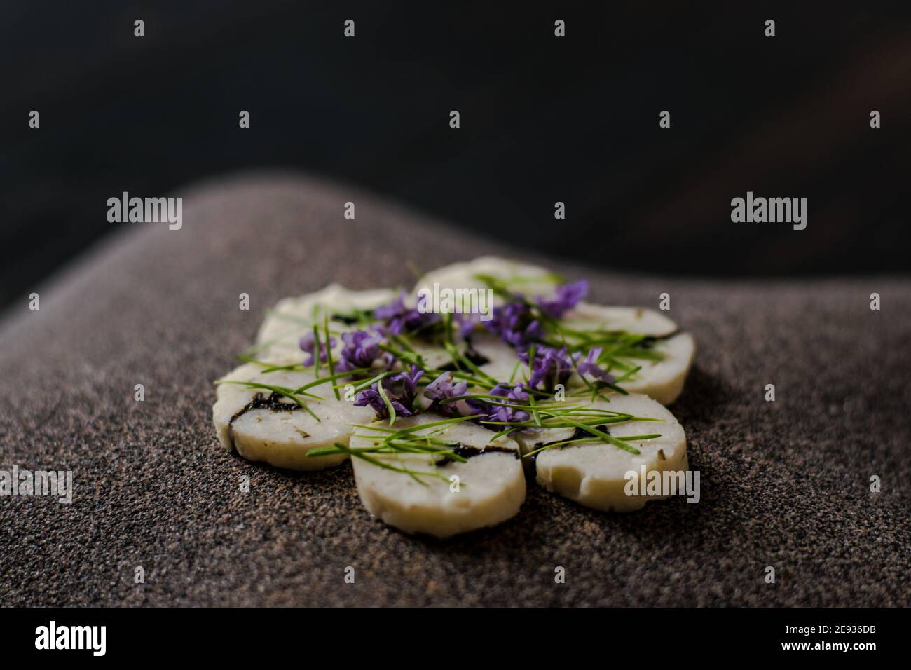Fischroulade auf einem interessanten Teller, der mit Tannennadeln verziert ist In einem Restaurant Stockfoto
