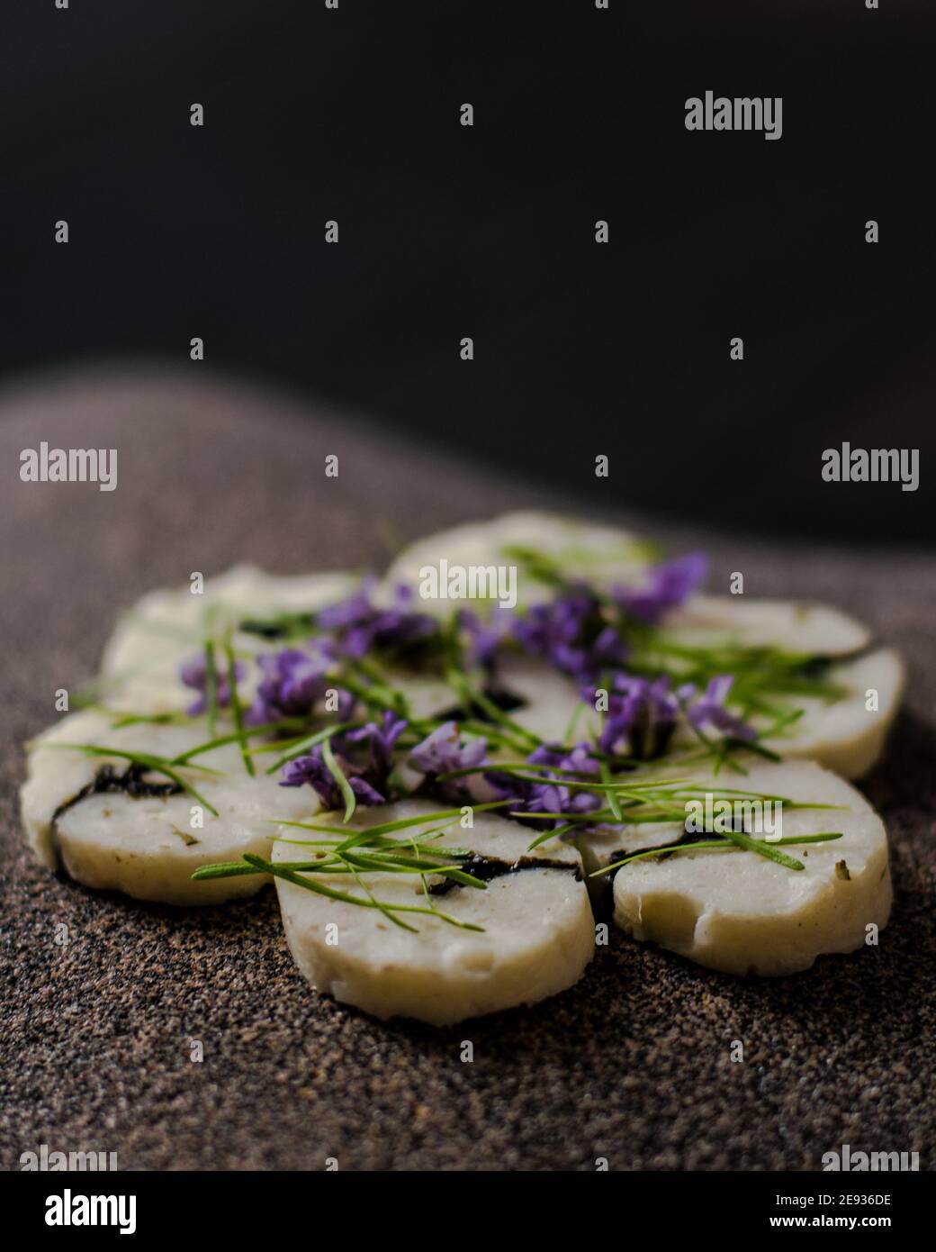 Fischroulade auf einem interessanten Teller, der mit Tannennadeln verziert ist In einem Restaurant Stockfoto