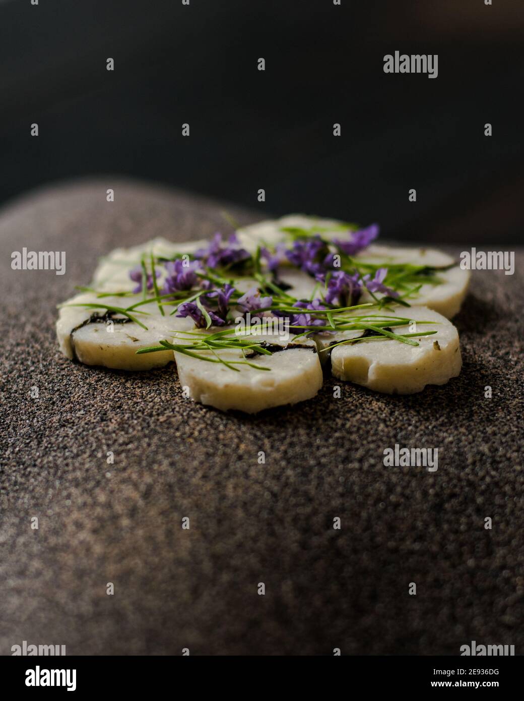 Fischroulade auf einem interessanten Teller, der mit Tannennadeln verziert ist In einem Restaurant Stockfoto