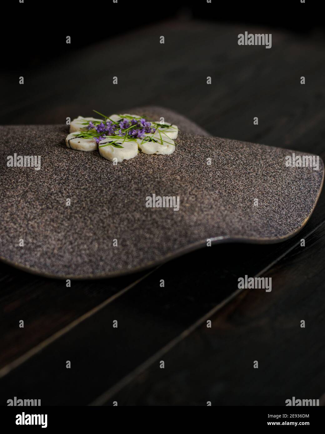 Fischroulade auf einem interessanten Teller, der mit Tannennadeln verziert ist In einem Restaurant Stockfoto