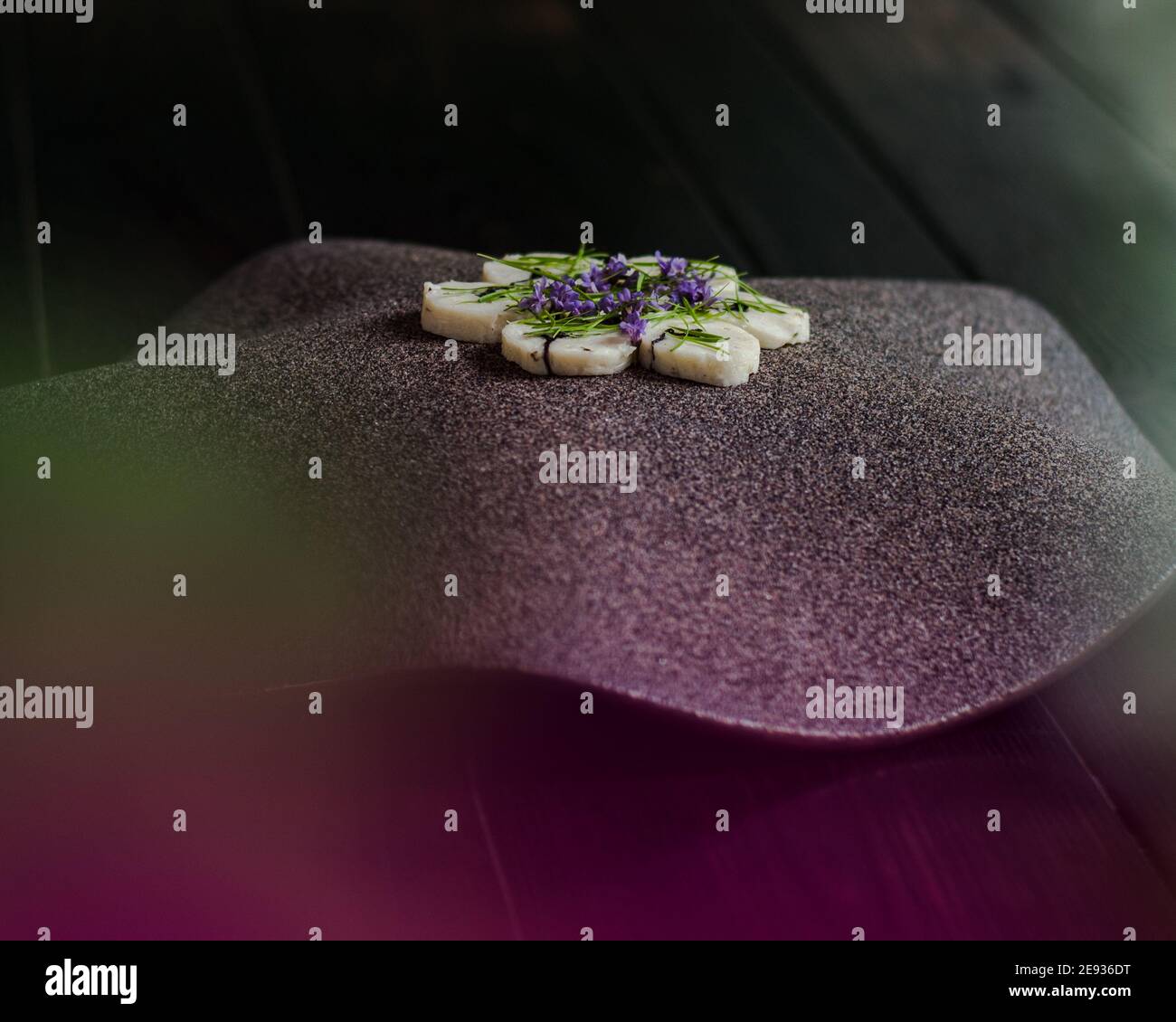 Fischroulade auf einem interessanten Teller, der mit Tannennadeln verziert ist In einem Restaurant Stockfoto