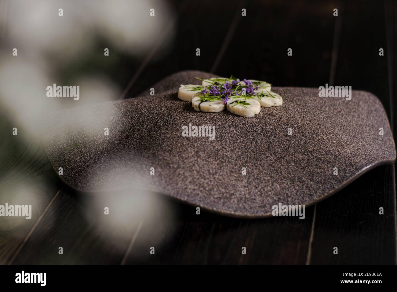Fischroulade auf einem interessanten Teller, der mit Tannennadeln verziert ist In einem Restaurant Stockfoto