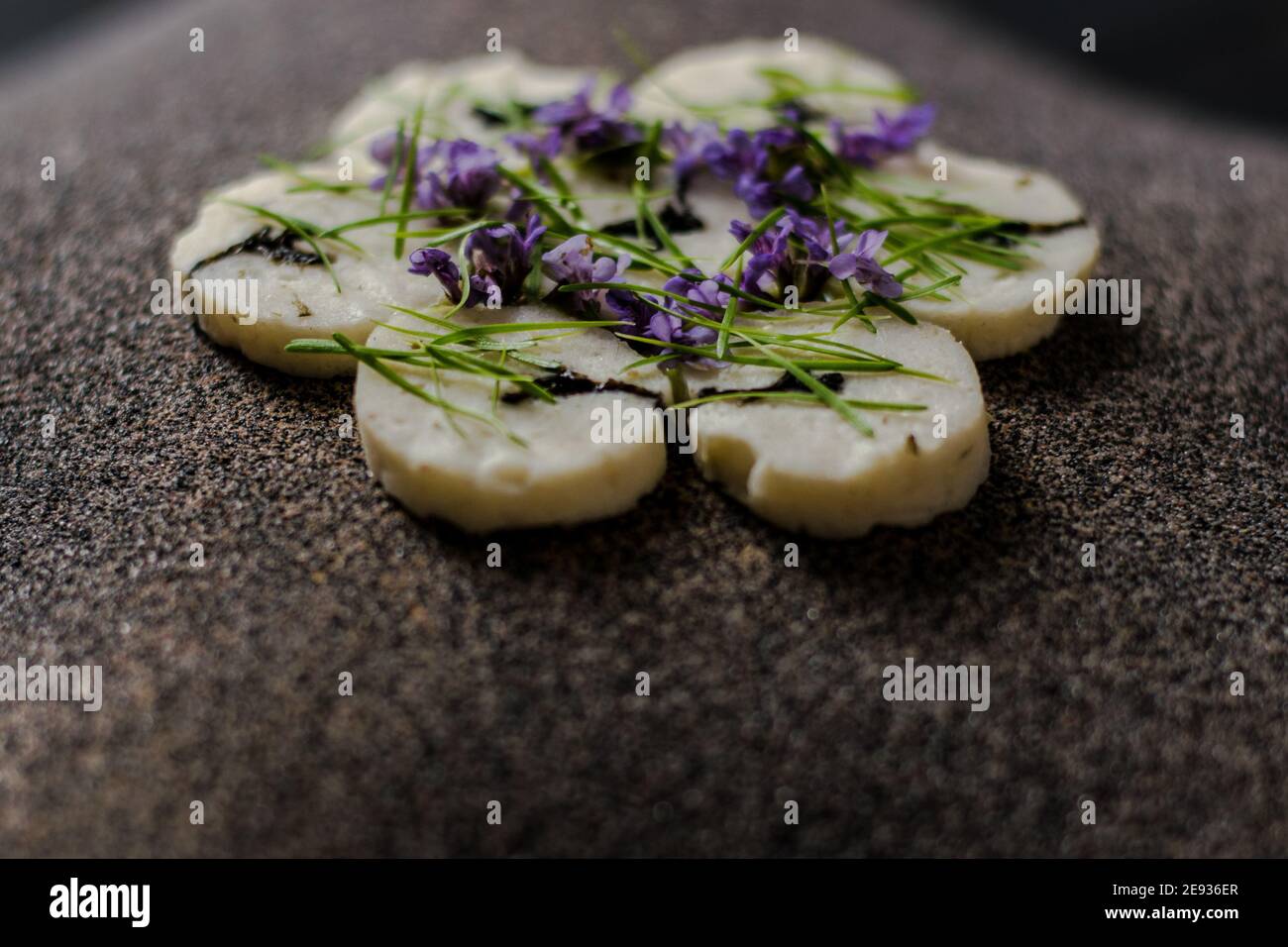 Fischroulade auf einem interessanten Teller, der mit Tannennadeln verziert ist In einem Restaurant Stockfoto