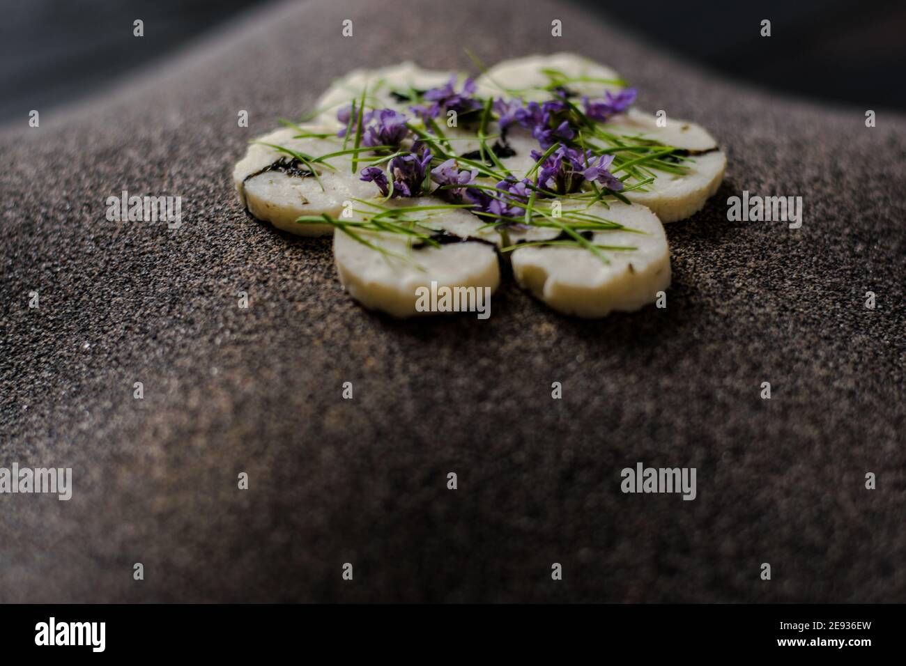 Fischroulade auf einem interessanten Teller, der mit Tannennadeln verziert ist In einem Restaurant Stockfoto
