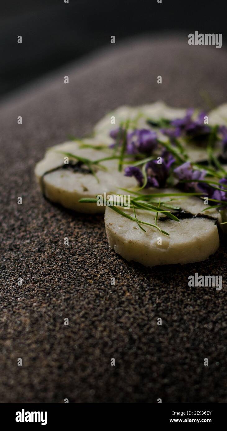 Fischroulade auf einem interessanten Teller, der mit Tannennadeln verziert ist In einem Restaurant Stockfoto