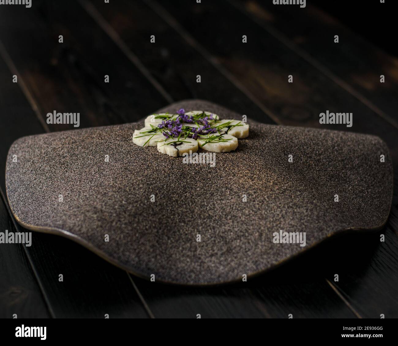 Fischroulade auf einem interessanten Teller, der mit Tannennadeln verziert ist In einem Restaurant Stockfoto