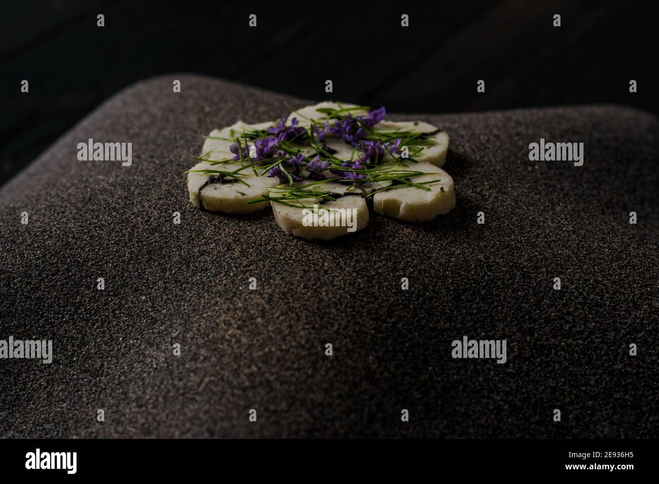 Fischroulade auf einem interessanten Teller, der mit Tannennadeln verziert ist In einem Restaurant Stockfoto