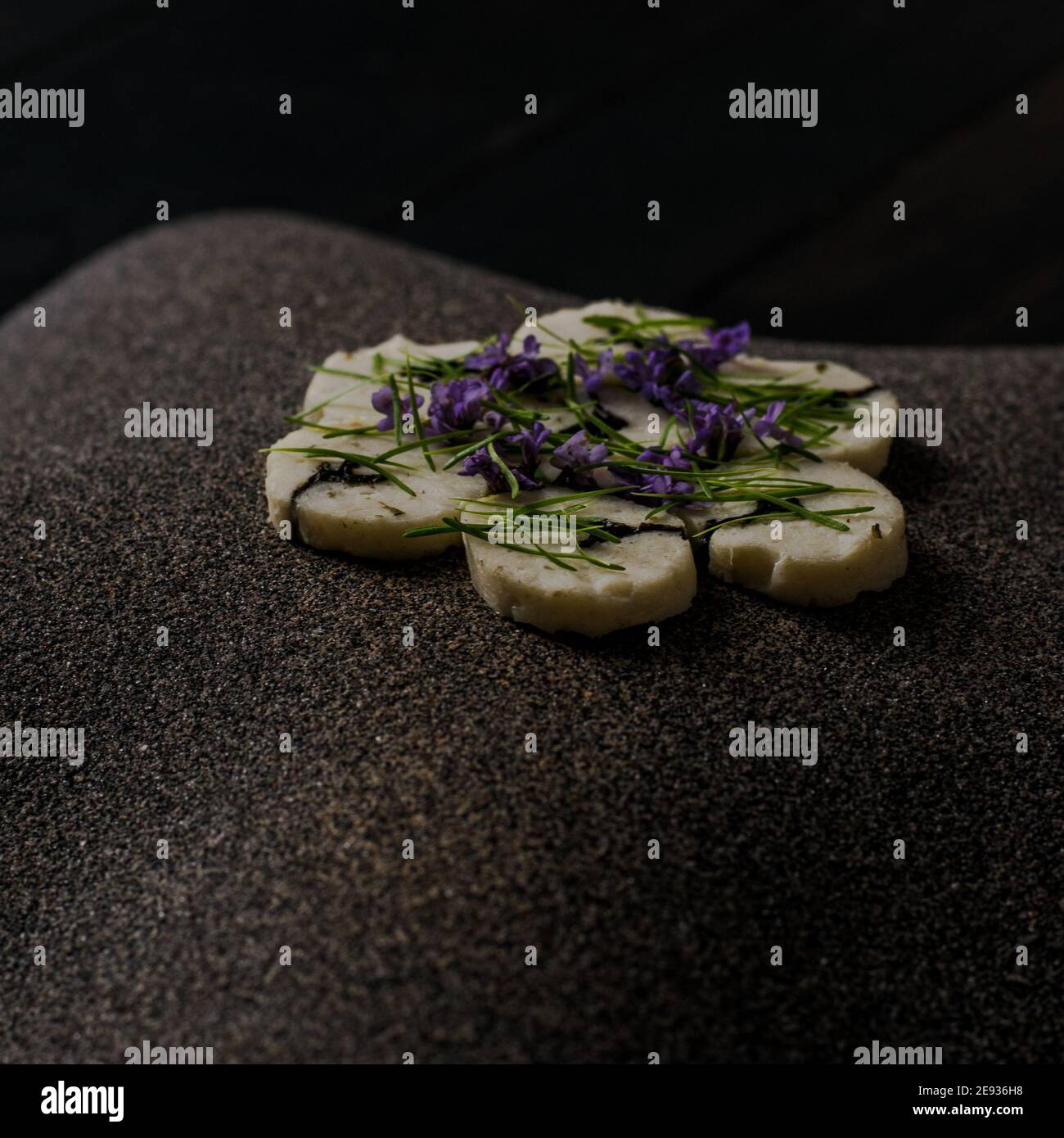 Fischroulade auf einem interessanten Teller, der mit Tannennadeln verziert ist In einem Restaurant Stockfoto
