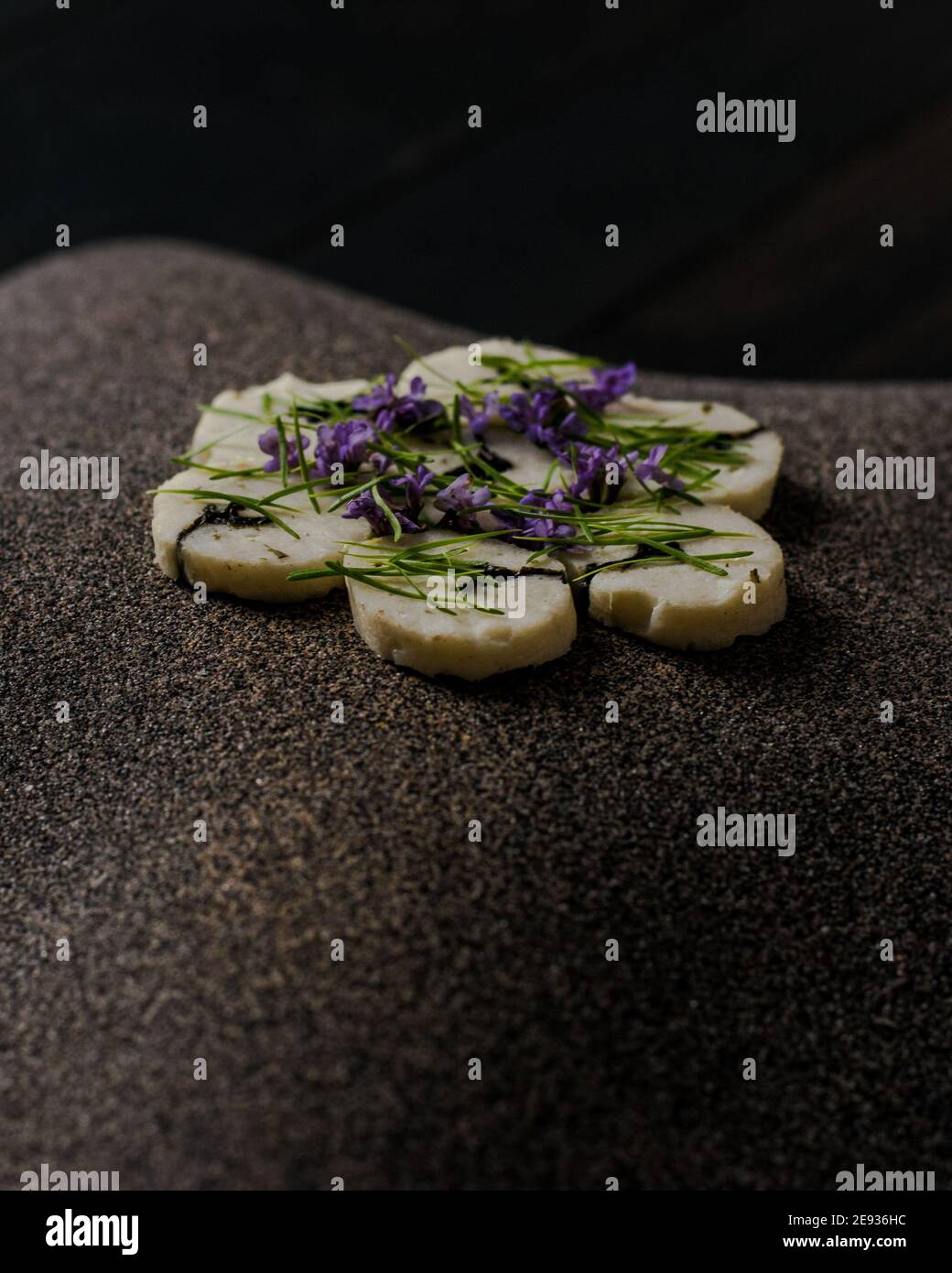 Fischroulade auf einem interessanten Teller, der mit Tannennadeln verziert ist In einem Restaurant Stockfoto