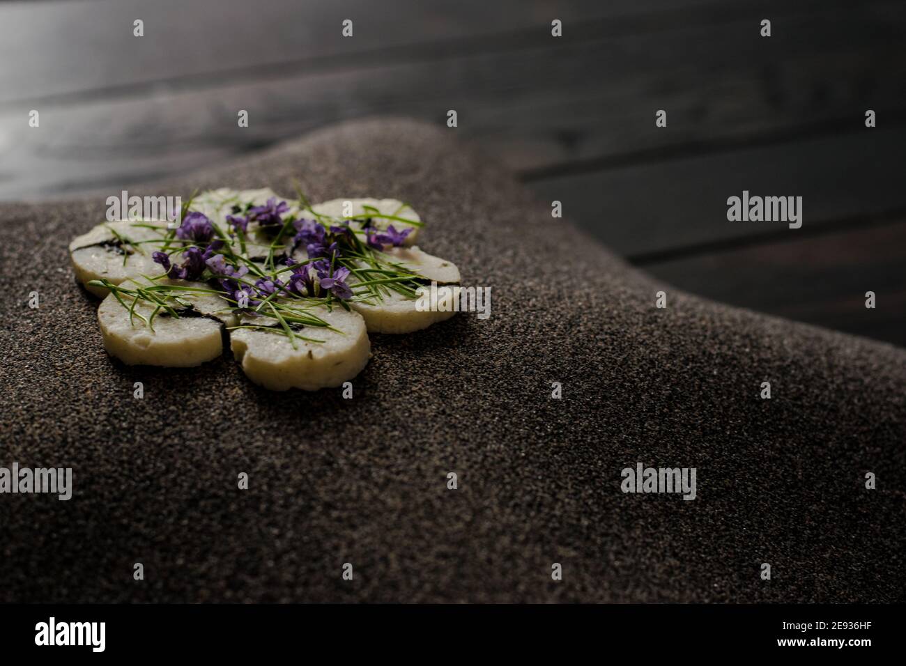 Fischroulade auf einem interessanten Teller, der mit Tannennadeln verziert ist In einem Restaurant Stockfoto