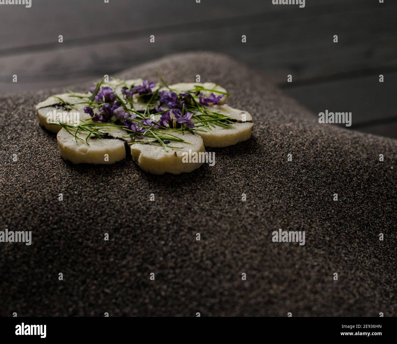 Fischroulade auf einem interessanten Teller, der mit Tannennadeln verziert ist In einem Restaurant Stockfoto