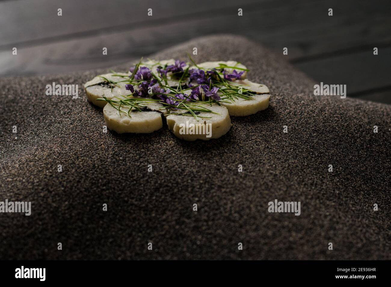 Fischroulade auf einem interessanten Teller, der mit Tannennadeln verziert ist In einem Restaurant Stockfoto