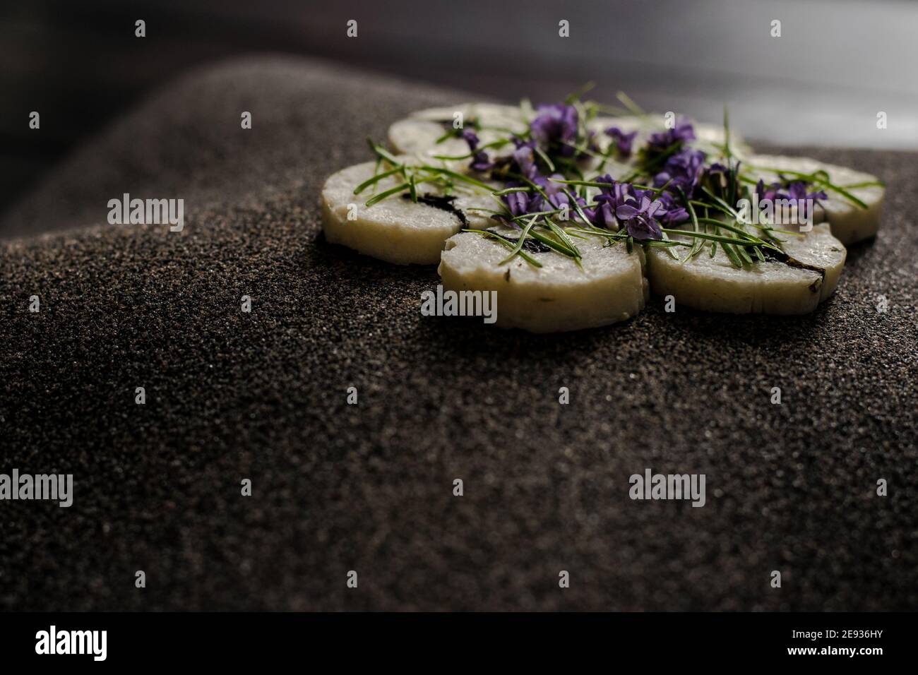 Fischroulade auf einem interessanten Teller, der mit Tannennadeln verziert ist In einem Restaurant Stockfoto