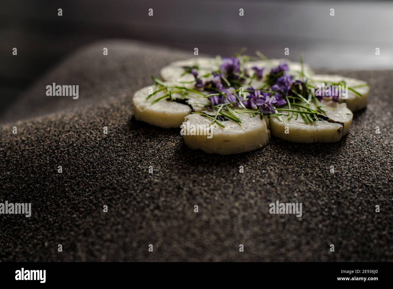 Fischroulade auf einem interessanten Teller, der mit Tannennadeln verziert ist In einem Restaurant Stockfoto