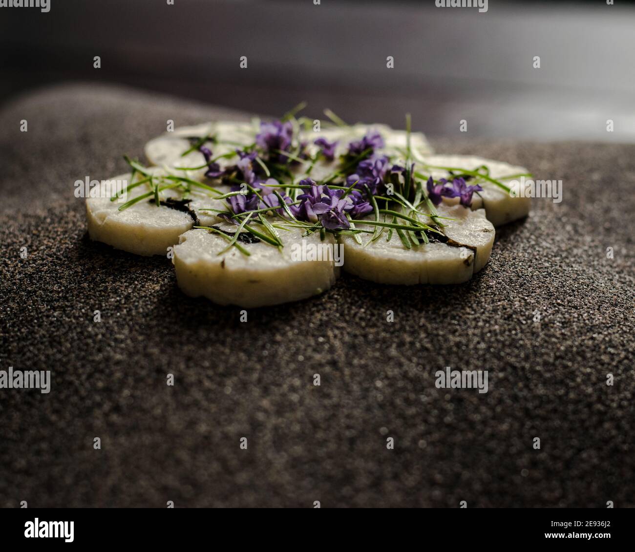 Fischroulade auf einem interessanten Teller, der mit Tannennadeln verziert ist In einem Restaurant Stockfoto