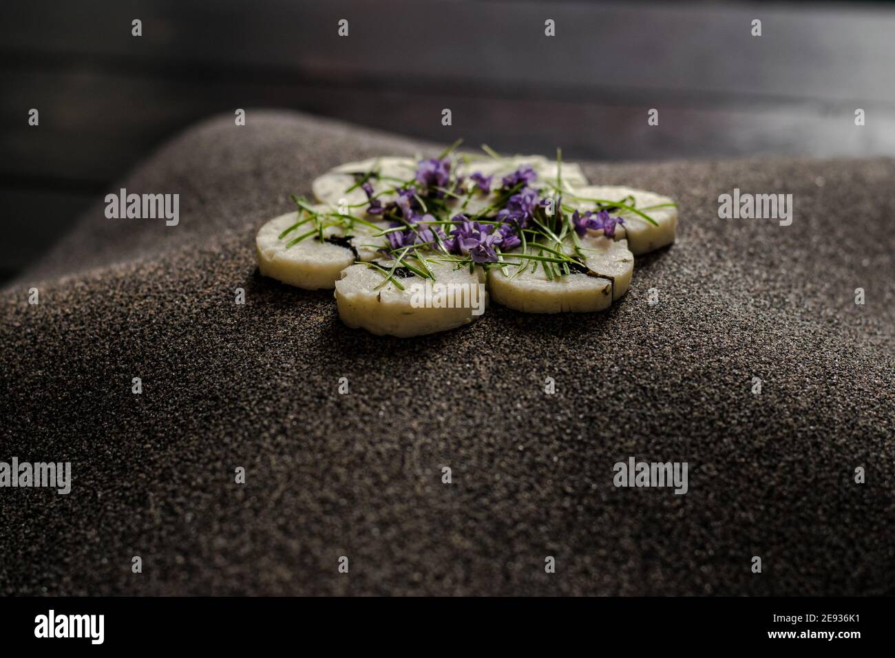Fischroulade auf einem interessanten Teller, der mit Tannennadeln verziert ist In einem Restaurant Stockfoto