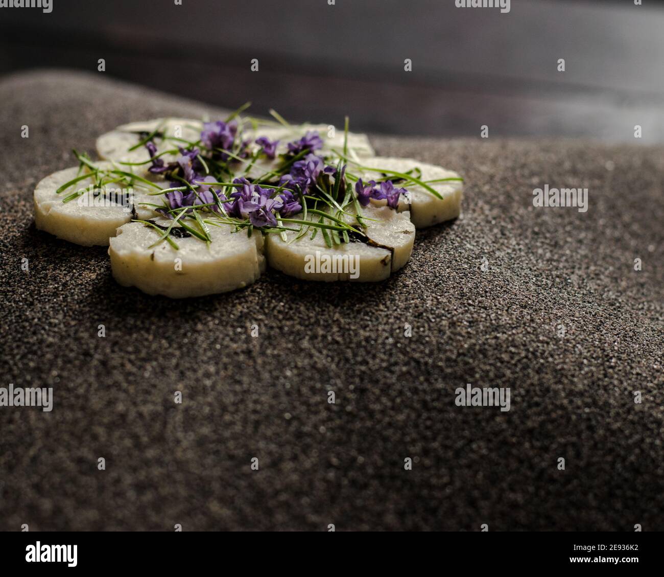 Fischroulade auf einem interessanten Teller, der mit Tannennadeln verziert ist In einem Restaurant Stockfoto