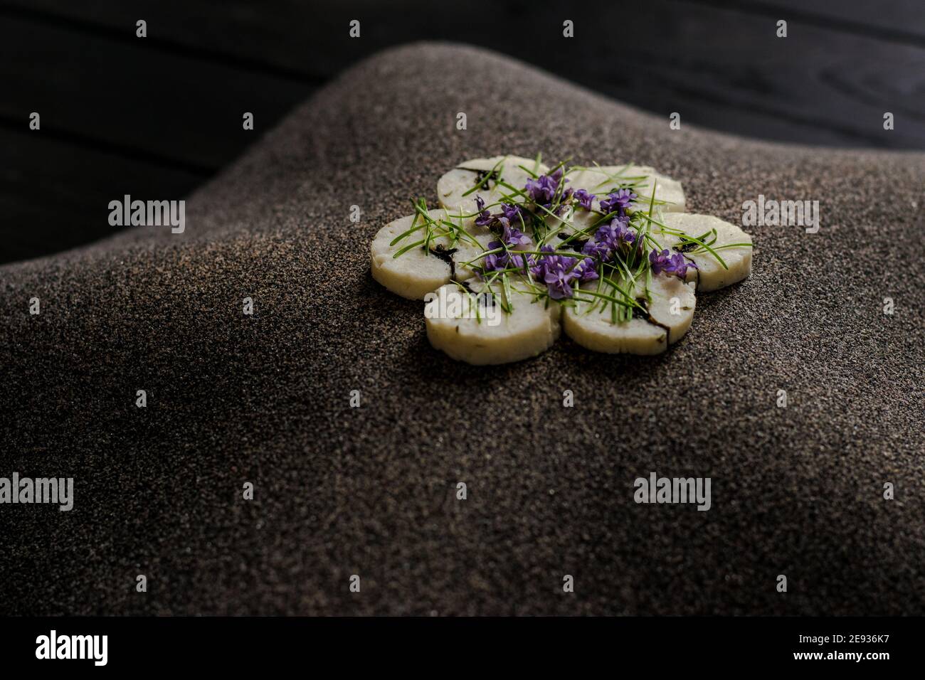 Fischroulade auf einem interessanten Teller, der mit Tannennadeln verziert ist In einem Restaurant Stockfoto