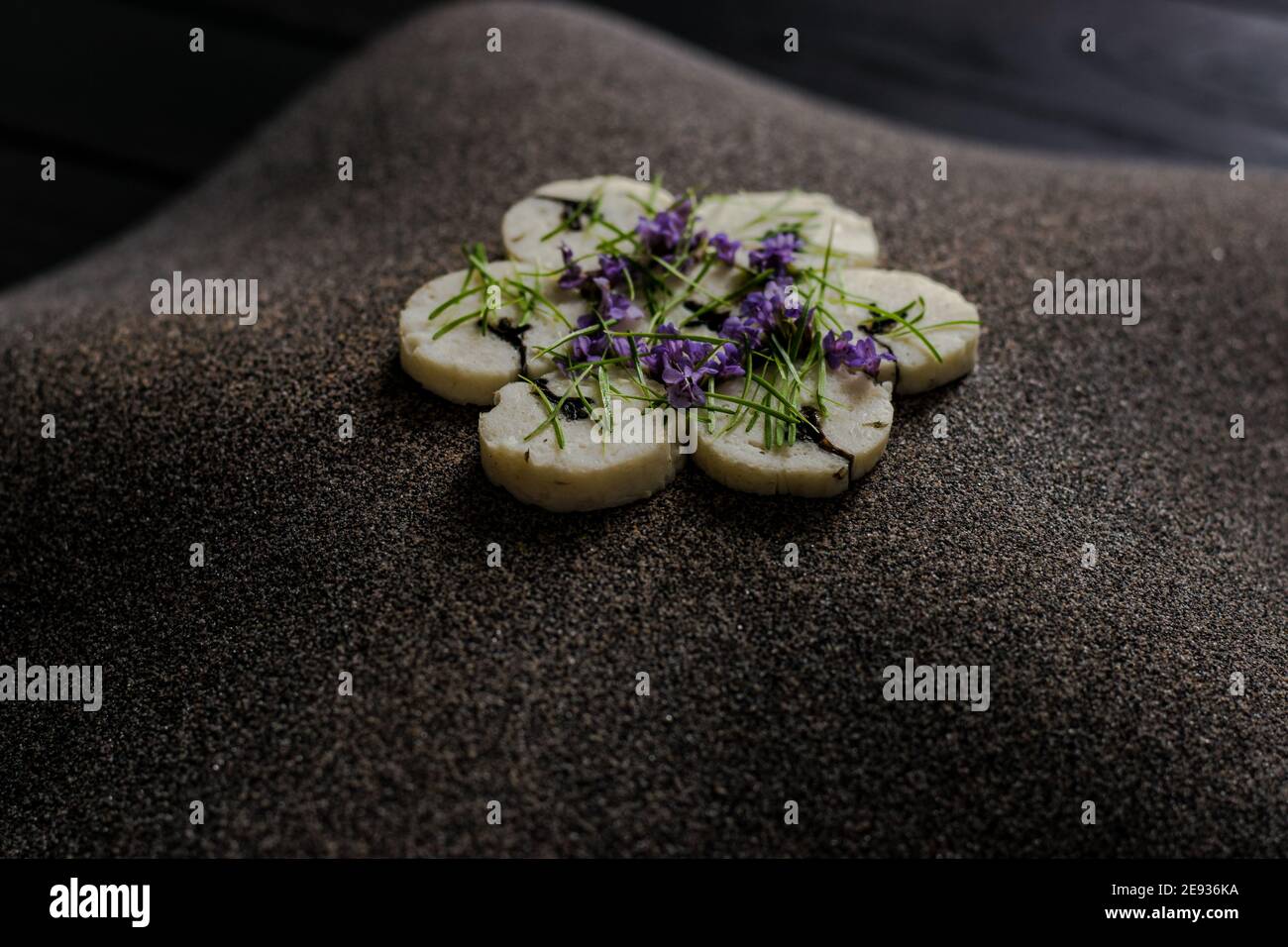 Fischroulade auf einem interessanten Teller, der mit Tannennadeln verziert ist In einem Restaurant Stockfoto