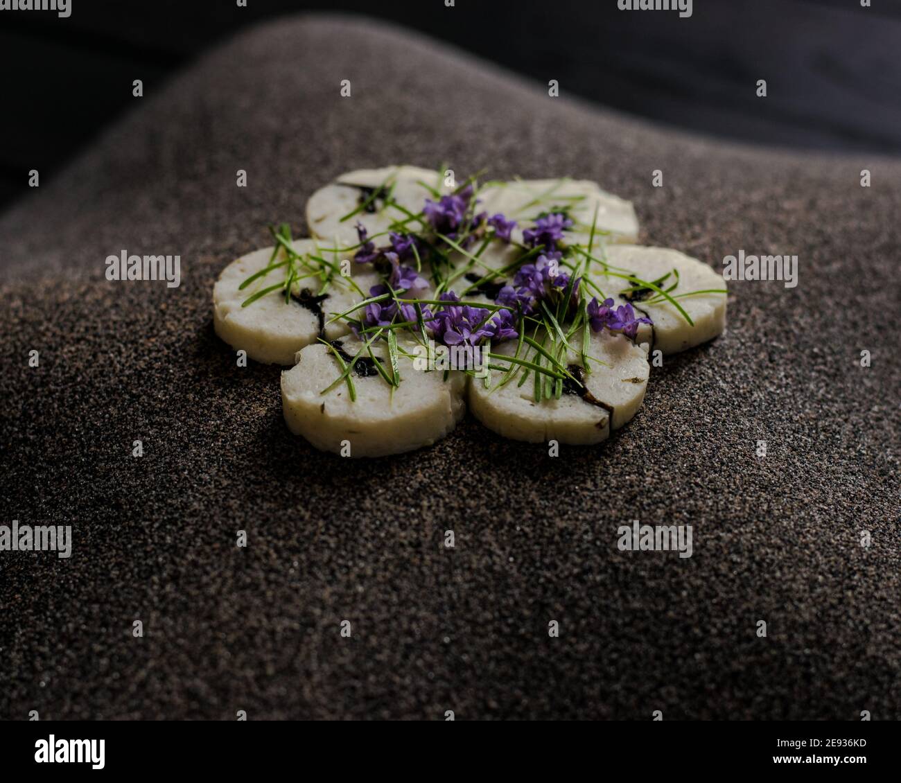 Fischroulade auf einem interessanten Teller, der mit Tannennadeln verziert ist In einem Restaurant Stockfoto
