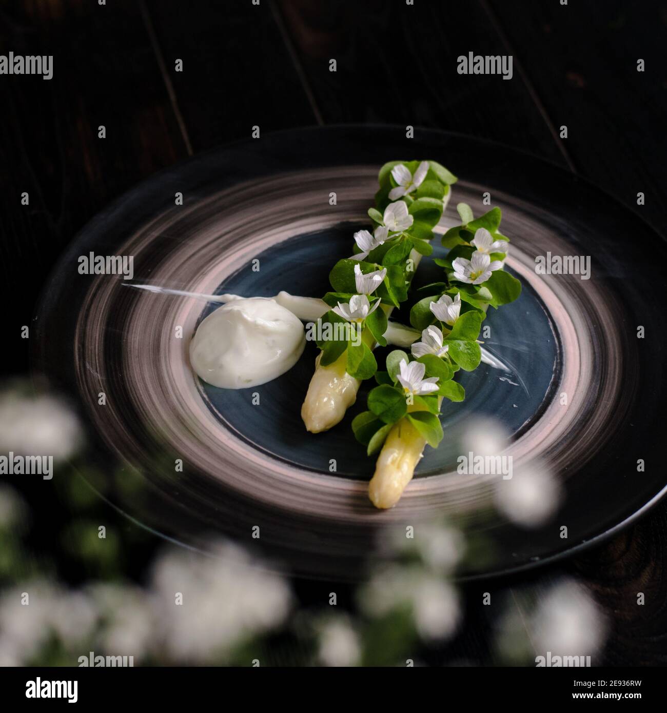 Gericht gekochten weißen Spargel plattiert und mit Weiß dekoriert Blumen und Sahne auf der Seite in einem Restaurant Stockfoto