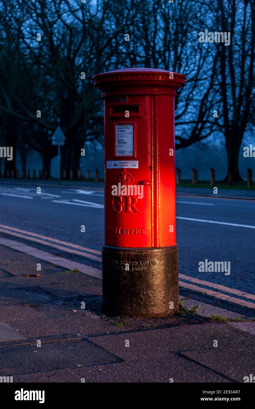 Rote GPO-Postbox mit Autoscheinwerfern an der Park Ave South, Northampton, England, Großbritannien. Stockfoto