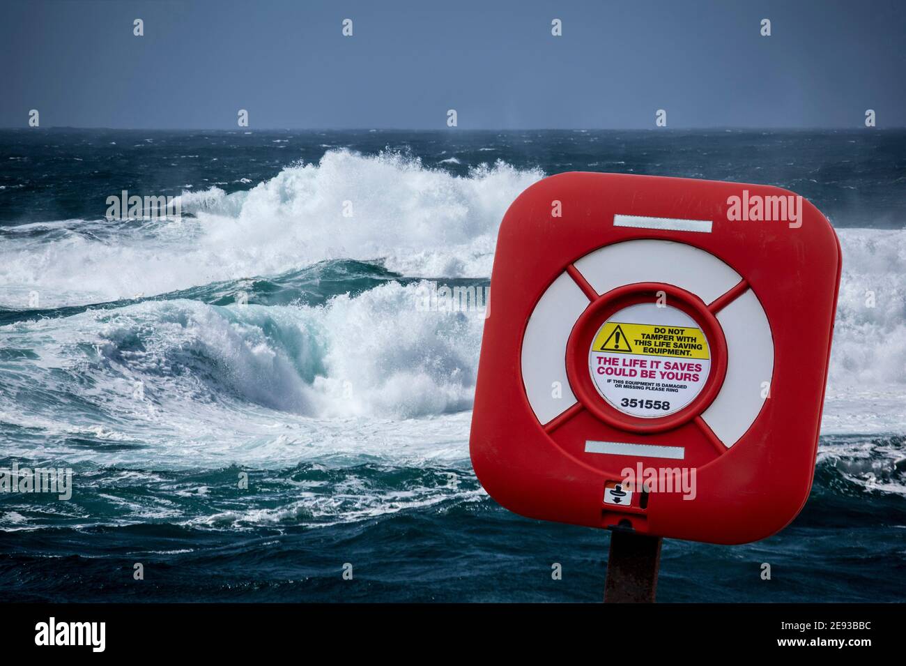 Rot-weißer Rettungsgurt gegen stürmisches Meer und hohe Wellen Stockfoto