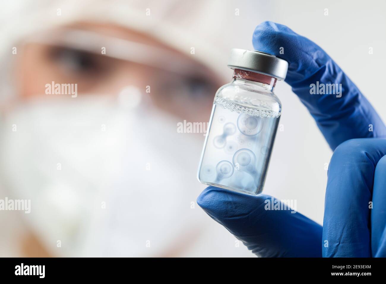 Zellteilung Prozess konzeptuelle Illustration, Lab Scientist hält Ampullen Fläschchen mit Zellkern-Moleküle Spalten, DNA-Replikation Verfahren, Mitos Stockfoto