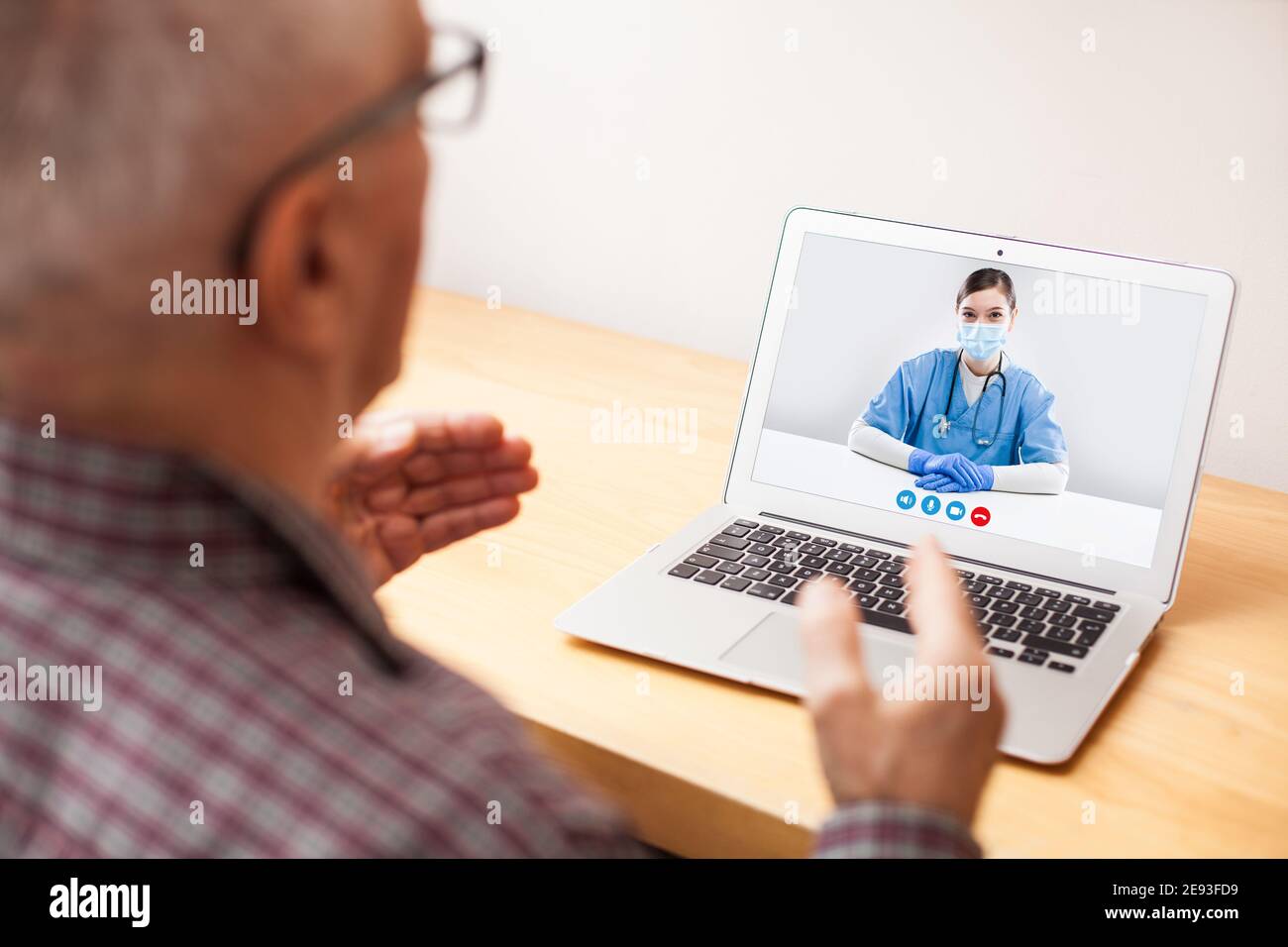 Junge NHS GP Arzt und ältere männliche Patienten Beratung über Videoanruf, virtueller medizinischer Check-up, Telefonbesuch des Arztes statt im Büro appo Stockfoto