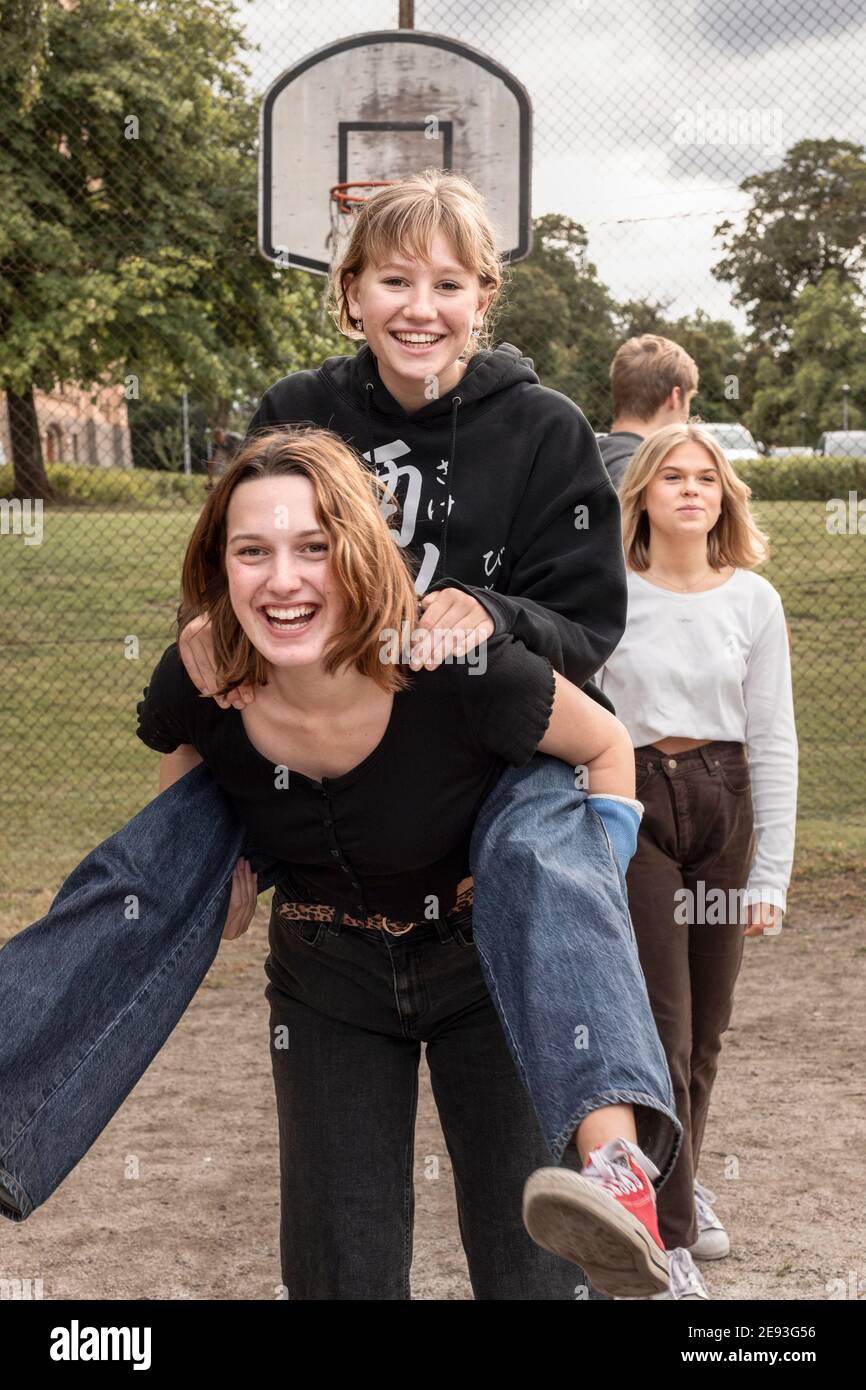 Teenager-Mädchen geben Freund piggyback-Fahrt Stockfoto