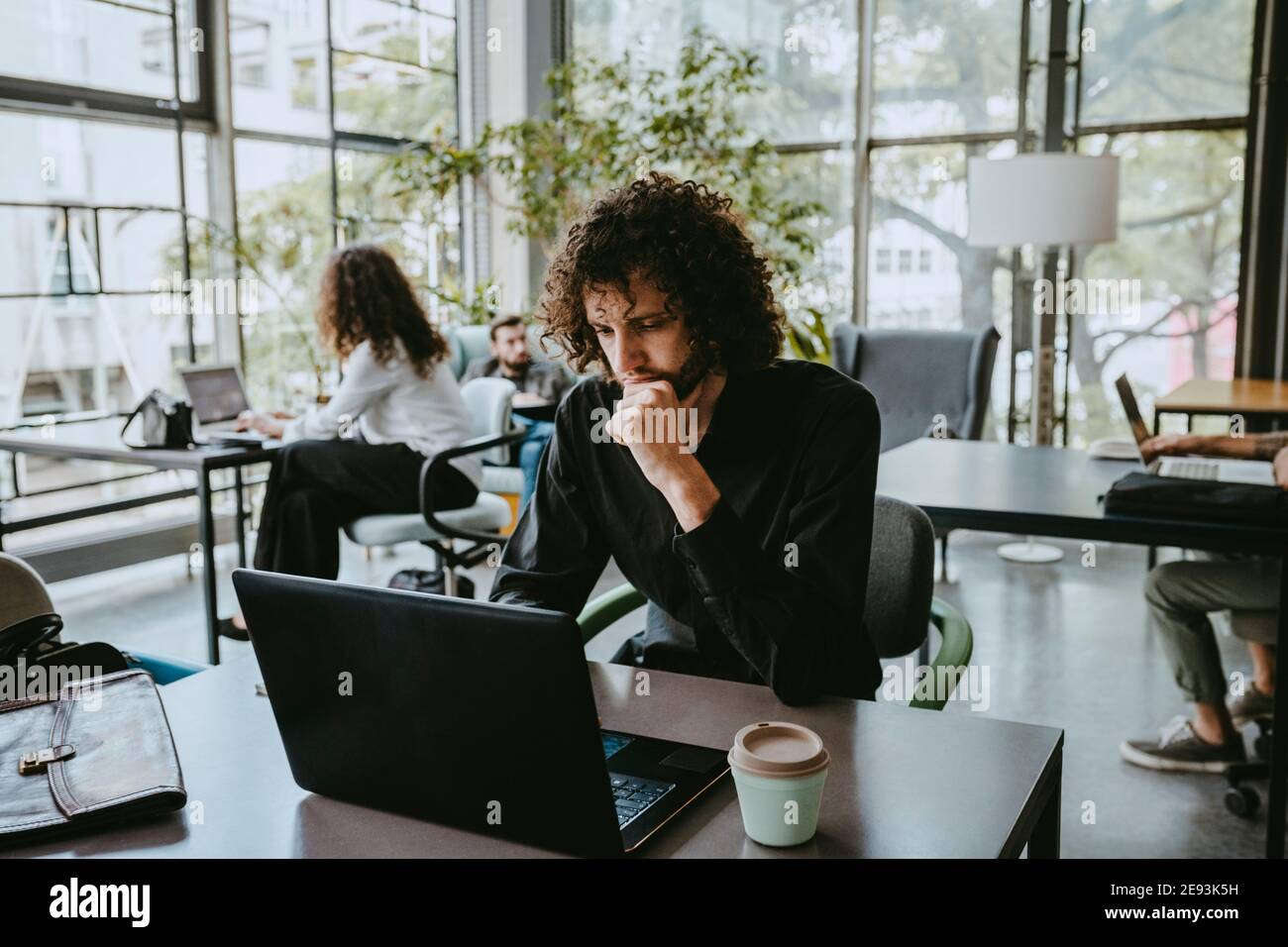 Männliche Unternehmer Kontemplation während der Arbeit auf Laptop in Coworking Büro Stockfoto