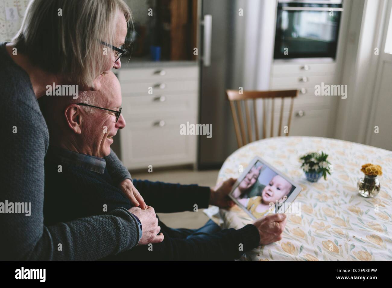 Lächelndes Paar mit Video-Chat mit Baby Enkel auf Tablet Stockfoto