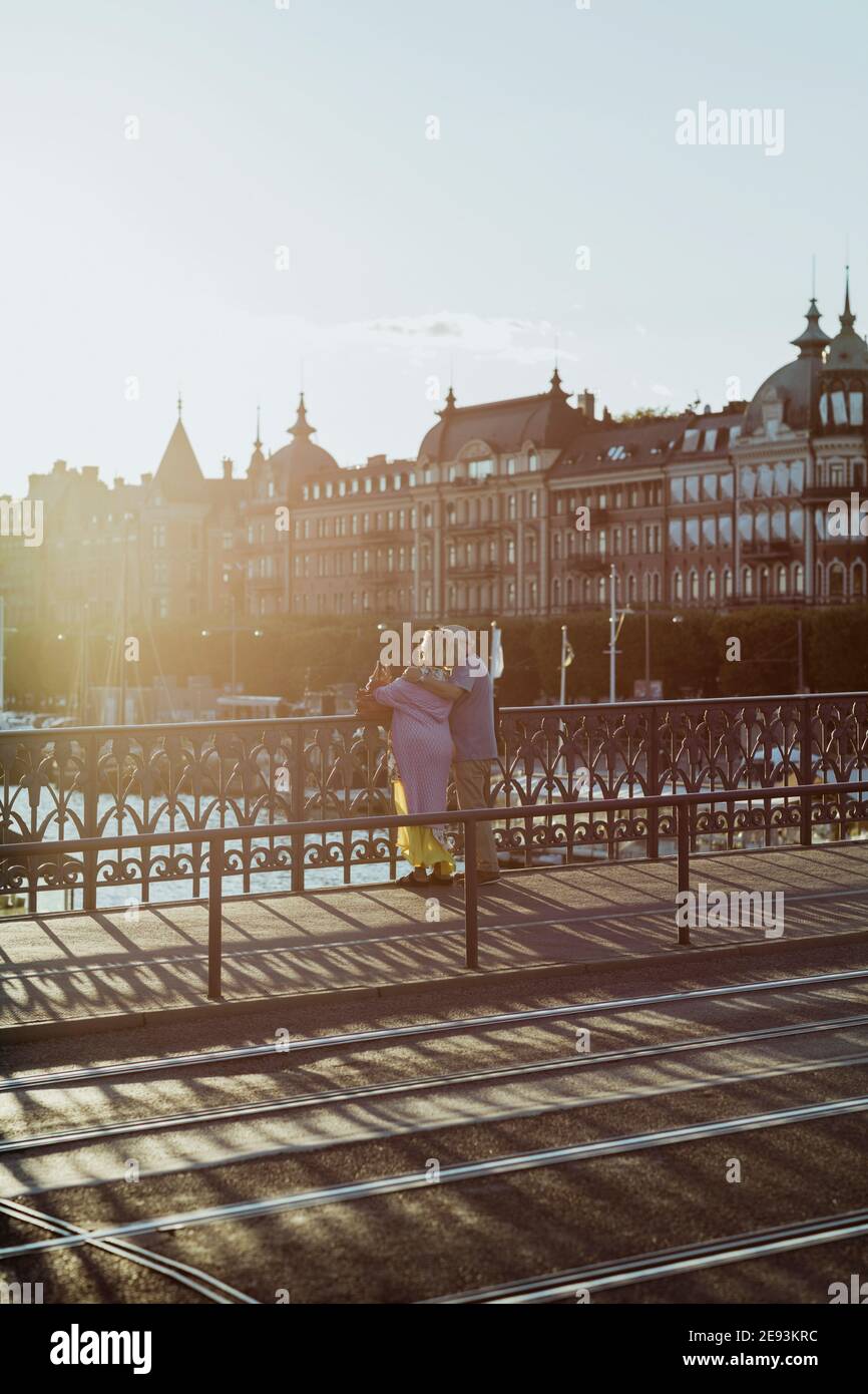 Rückansicht Seniorenpaar, das während des Urlaubs auf der Brücke steht Stockfoto