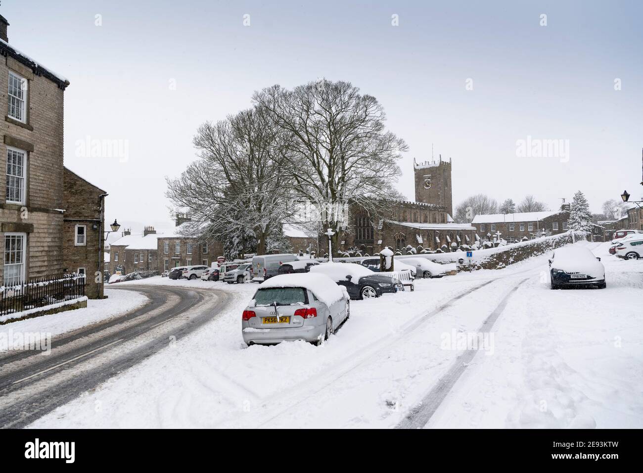 Wetter, Askrigg, North Yorkshire, UK. Februar 2021. Die St. Oswalds Church in Askrigg, wo die ursprüngliche James Heriot-Serie gedreht wurde, verwandelt sich in eine klassische Winterszene, da schwerer Schnee in der Gegend Reisestau brachte. Quelle: Wayne HUTCHINSON/Alamy Live News Stockfoto