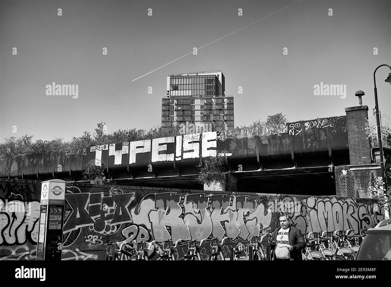 Urban Graffiti-Szene in Schwarz-weiß mit auffälliger Typografie und Hochhaus in London Stockfoto