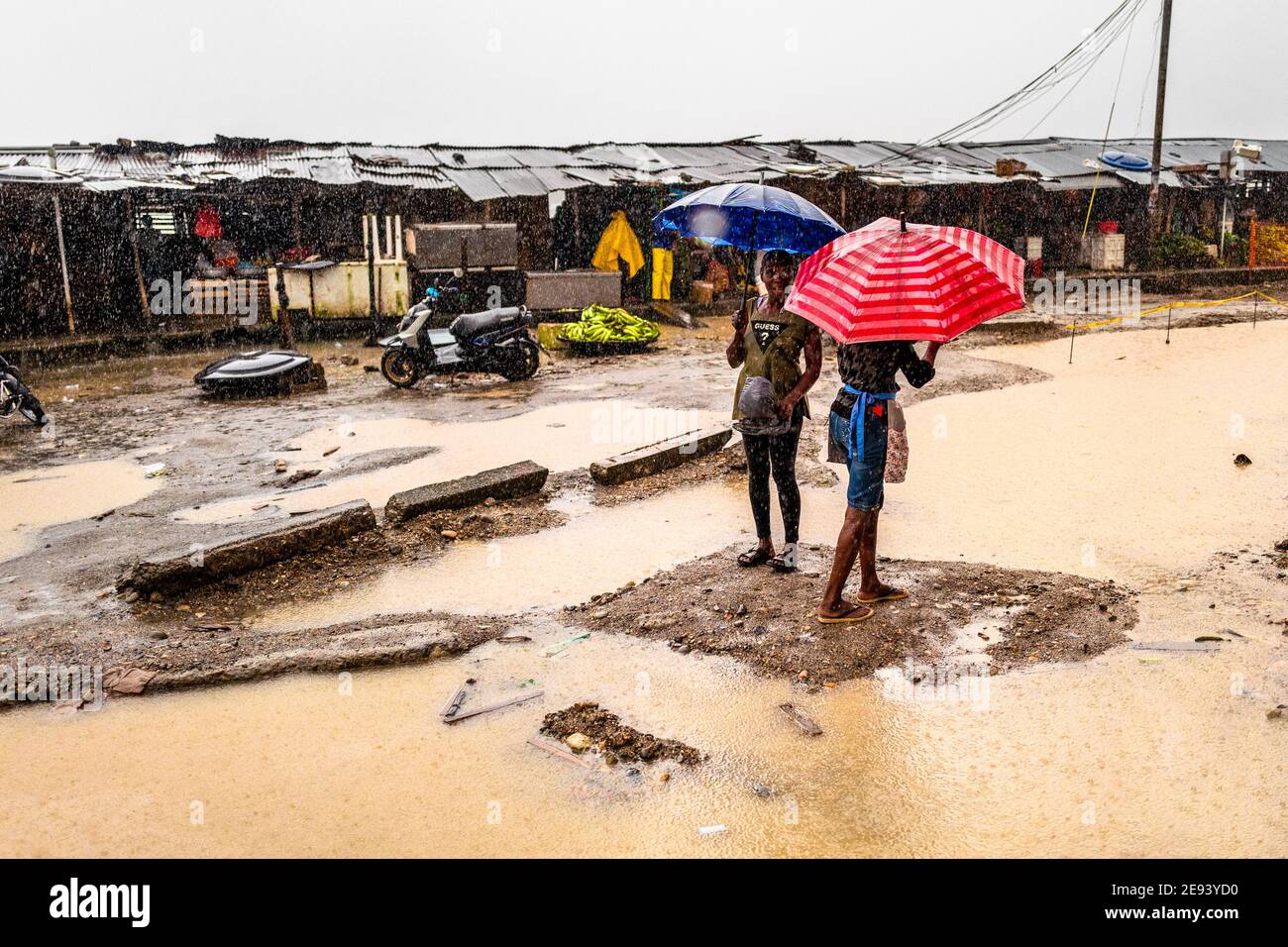 Afro-kolumbianische Händler laufen bei starkem Regen in Quibdó, Chocó, der pazifischen Region Kolumbiens, auf einem Straßenmarkt entlang des Flusses Atrato. Stockfoto