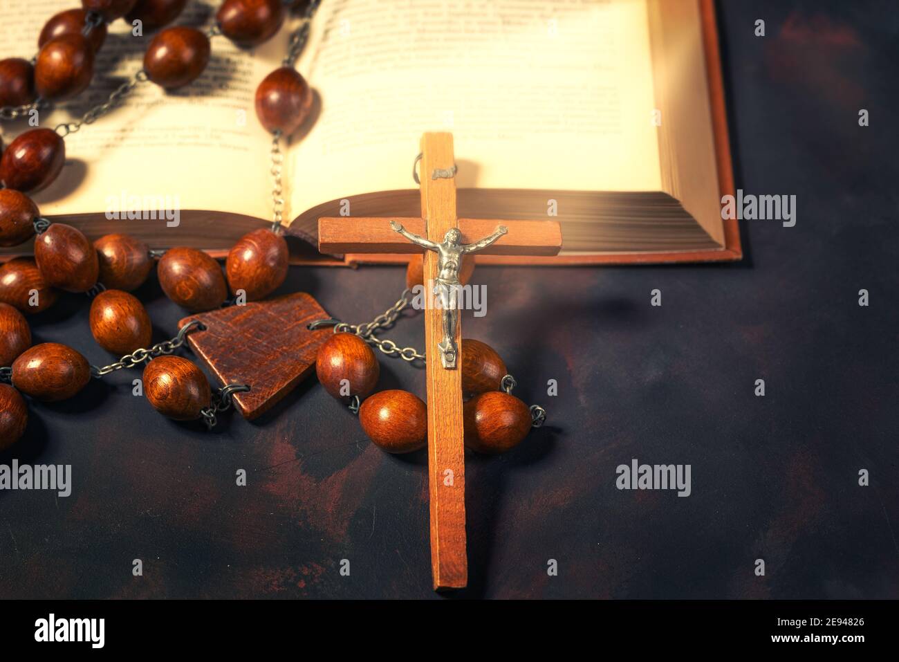 Große hölzerne Rosenkranz Perlen und Kruzifix Kreuz mit jesus und bibel Buch, spirituelle Atmosphäre, Religion Konzept. Stockfoto