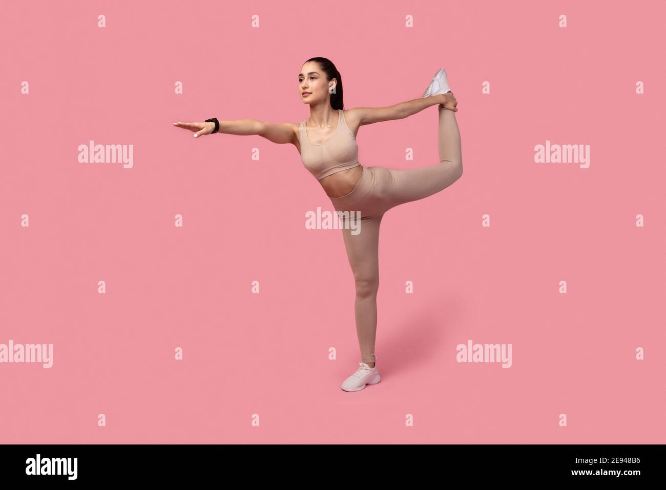 Lächelnde Junge Frau Macht Balance Übung Mit Bein Erhöhen Stockfoto