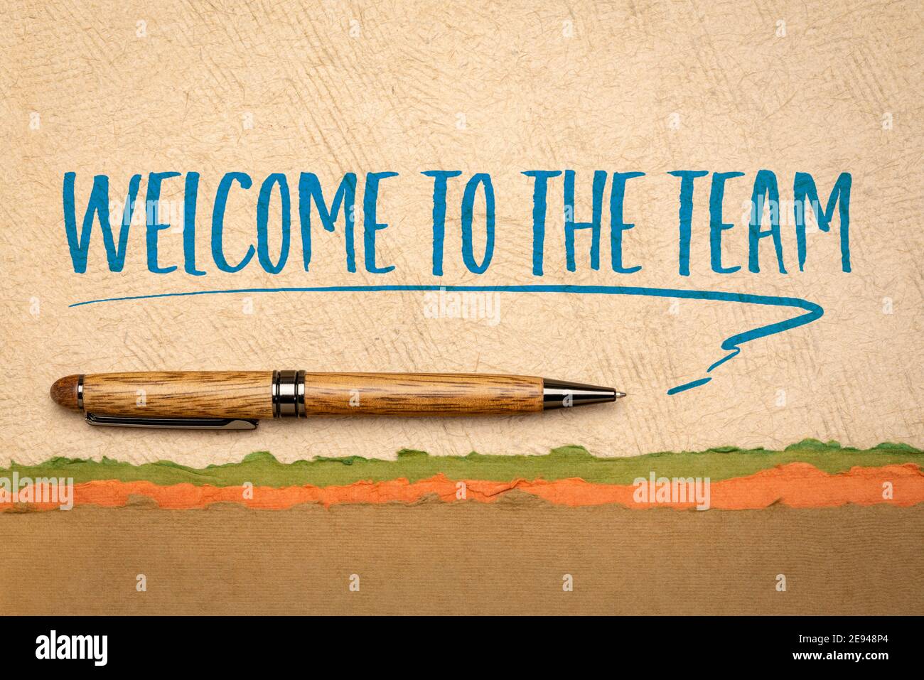 Willkommen im Team Grüße - motivierende Handschrift auf handgeschöpftem Strukturpapier mit stilvollem Stift, Business- und Teamwork-Konzept Stockfoto